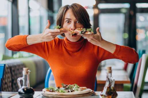 Młoda ładna kobieta jedzenie pizzy w barze